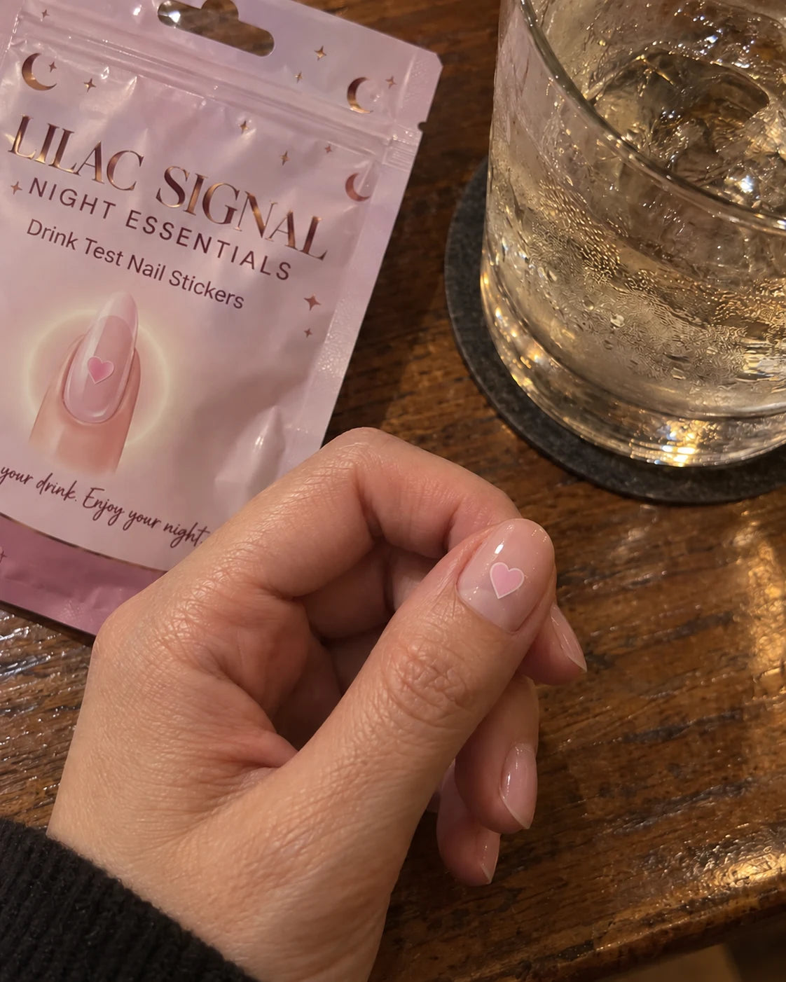 A small pink heart sticker on a nail